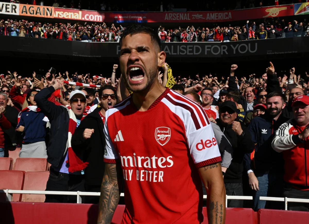 Bruno Guimaraes celebrates scoring a goal for Arsenal, with the crowd cheering behind him.
